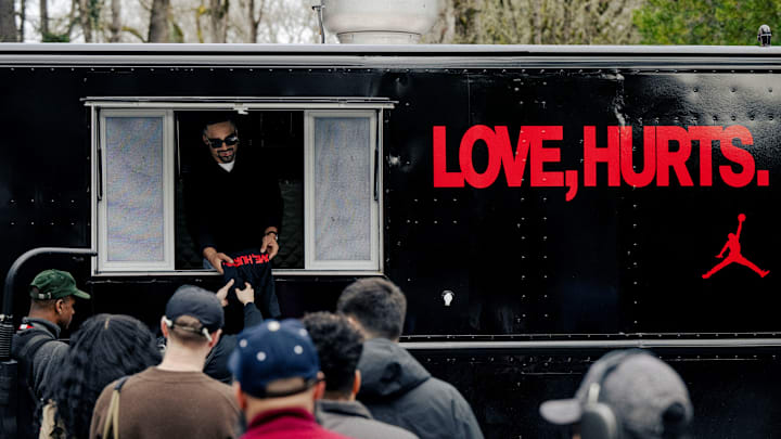 Jalen Hurts hands shirts to Jordan Brand family members.