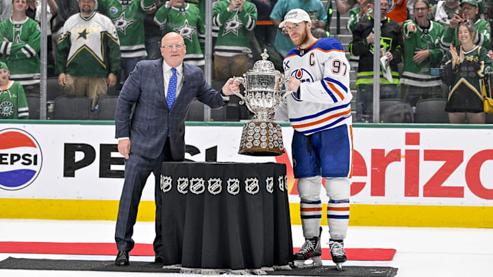 May 29, 2025; Dallas, Texas, USA; NHL deputy commissioner Bill Daly hands the Clarence S. Campbell Bowl to Edmonton Oilers center Connor McDavid (97) after the game between the Dallas Stars and the Edmonton Oilers in game five of the Western Conference Final of the 2025 Stanley Cup Playoffs at American Airlines Center. Mandatory Credit: Jerome Miron-Imagn Images