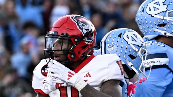 Nov 30, 2024; Chapel Hill, North Carolina, USA; North Carolina Tar Heels wide receiver J.J. Jones (13) reacts after scoring a touchdown as North Carolina State Wolfpack cornerback Devon Marshall (16) is in the foreground in the second quarter at Kenan Memorial Stadium. Mandatory Credit: Bob Donnan-Imagn Images