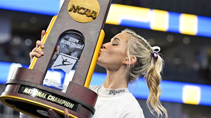 Apr 20, 2024; Fort Worth, TX, USA; LSU Tigers gymnast Olivia Dunne kisses the championship trophy after the LSU Tigers gymnastics team wins the national championship in the 2024 Womens National Gymnastics Championship at Dickies Arena. Mandatory Credit: Jerome Miron-Imagn Images Apr 20, 2024; Fort Worth, TX, USA; LSU Tigers gymnast Olivia Dunne kisses the championship trophy after the LSU Tigers gymnastics team wins the national championship in the 2024 Womens National Gymnastics Championship at Dickies Arena. Mandatory Credit: Jerome Miron-Imagn Images