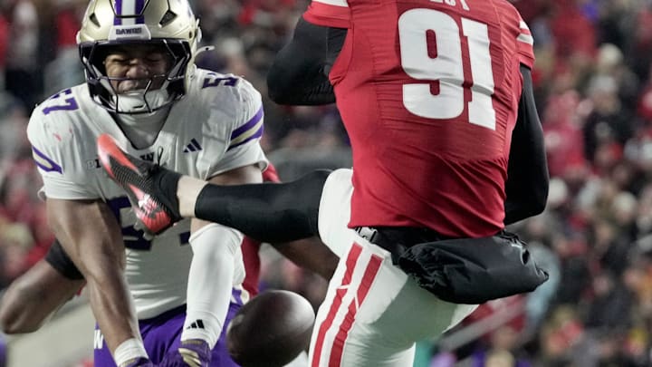 Washington's Anthony Ward (57) blocks Sean West's Wisconsin punt. Washington's Anthony Ward (57) blocks Sean West's Wisconsin punt.