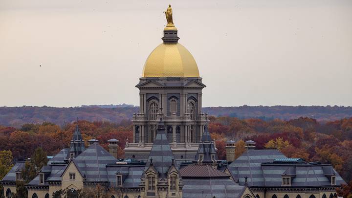 Nov 8, 2025; South Bend, Indiana, USA; The Golden Dome atop the Main Building with fall foliage before the Notre Dame Fighting Irish vs. the Navy Midshipmen logos at Notre Dame Stadium. Mandatory Credit: Michael Caterina-Imagn Images Nov 8, 2025; South Bend, Indiana, USA; The Golden Dome atop the Main Building with fall foliage before the Notre Dame Fighting Irish vs. the Navy Midshipmen logos at Notre Dame Stadium. Mandatory Credit: Michael Caterina-Imagn Images