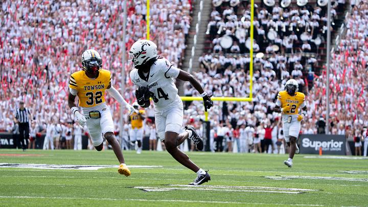 Cincinnati Bearcats wide receiver Sterling Berkhalter (84) scores a touchdown as Towson Tigers defensive back Zakaa Brown (32) attempts to stop him in the first quarter of the College Football game at Nippert Stadium in Cincinnati on Saturday, Aug. 31, 2024.