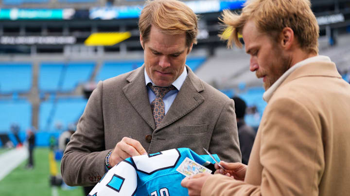 CHARLOTTE, NORTH CAROLINA - DECEMBER 15: FOX Broadcaster Greg Olsen signs autographs before the game between the Carolina Panthers and the Dallas Cowboys at Bank of America Stadium on December 15, 2024 in Charlotte, North Carolina. 