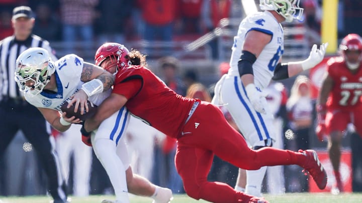 Louisville Cardinals defensive lineman Ashton Gillotte (9) brings down Kentucky Wildcats quarterback Devin Leary (13) for a sack in the first half Saturday. Nov. 25, 2023.