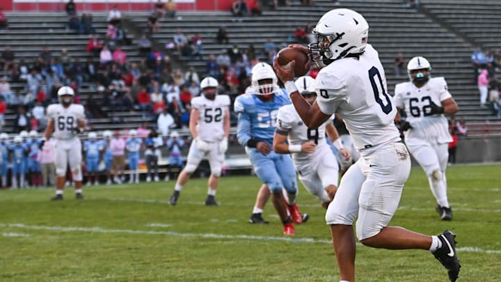 East Lansing's Jace Clarizio snags a pass against Everett, Friday, Oct. 11, 2024, which he ran in for a Trojan TD. East Lansing won 39-26.