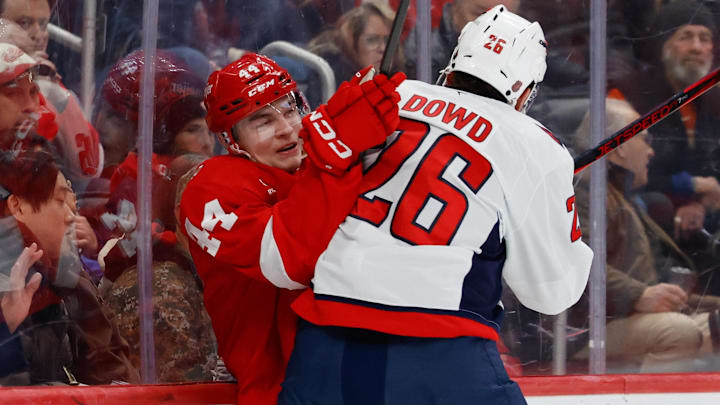 Jan 29, 2026; Detroit, Michigan, USA;  Washington Capitals center Nic Dowd (26) checks Detroit Red Wings defenseman Axel Sandin-Pellikka (44) in the first period at Little Caesars Arena. Mandatory Credit: Rick Osentoski-Imagn Images