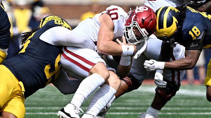 Sep 12, 2026; Ann Arbor, Michigan, USA;  Michigan Wolverines defensive line Trey Pierce (95) and linebacker Troy Bowles (18) tackle Oklahoma Sooners quarterback John Mateer (10) during the second quarter at Michigan Stadium.  Mandatory Credit: Lon Horwedel-Imagn Images