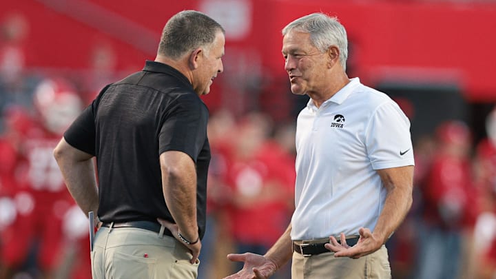 Sep 24, 2022; Piscataway, New Jersey, USA; Iowa Hawkeyes head coach Kirk Ferentz (right) talks with Rutgers Scarlet Knights head coach Greg Schiano before the game at SHI Stadium. Mandatory Credit: Vincent Carchietta-Imagn Images
