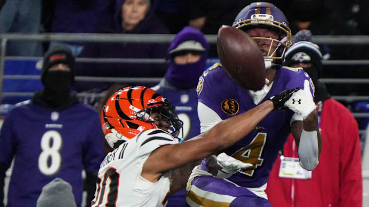 Bengals DJ Turner II (20) disrupts the Ravens ball carrier during their game at M&T Bank Stadium on Thanksgiving Thursday November 27, 2025. The Bengals won the game with a final score of 33-14.