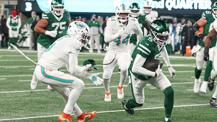 New York Jets wide receiver Garrett Wilson (5) breaks a tackle by Miami Dolphins cornerback Jalen Ramsey (5) during the first half at MetLife Stadium.