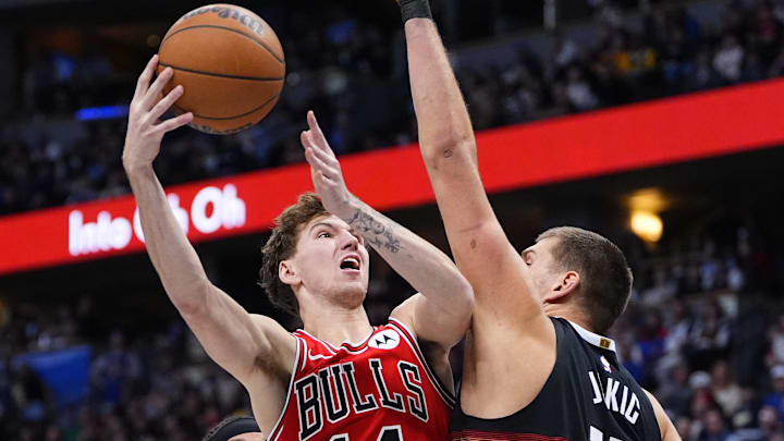 Nov 17, 2025; Denver, Colorado, USA; Chicago Bulls forward Matas Buzelis (14) shoots the ball over Denver Nuggets center Nikola Jokic (15) in the second quarter at Ball Arena. Mandatory Credit: Ron Chenoy-Imagn Images