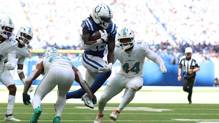 Miami Dolphins safety Minkah Fitzpatrick (29) and linebacker Chop Robinson (44) close in on Indianapolis Colts wide receiver during the second half of the 2024 season opener at Lucas Oil Stadium.