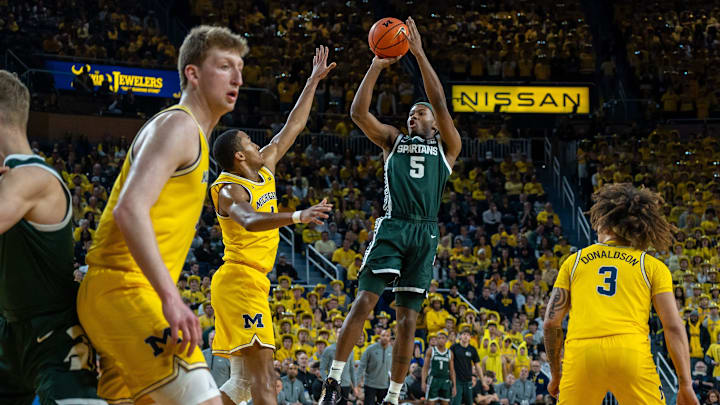 Feb 21, 2025; Ann Arbor, MI, USA; Michigan State player Tre Holloman (5) shoots over a Michigan defender during the first half of their matchup at Crisler Center. Mandatory Credit: David Rodriguez Munoz-Imagn Images