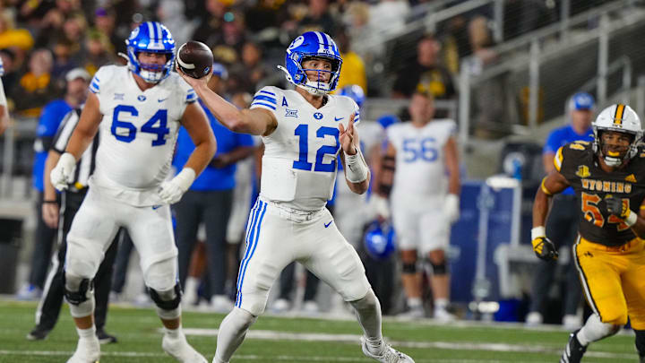 Sep 14, 2024; Laramie, Wyoming, USA; Brigham Young Cougars quarterback Jake Retzlaff (12) throws a touchdown pass against the Wyoming Cowboys during the third quarter at Jonah Field at War Memorial Stadium. Sep 14, 2024; Laramie, Wyoming, USA; Brigham Young Cougars quarterback Jake Retzlaff (12) throws a touchdown pass against the Wyoming Cowboys during the third quarter at Jonah Field at War Memorial Stadium.