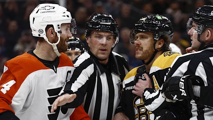 Dec 7, 2024; Boston, Massachusetts, USA; The linesman gets between Philadelphia Flyers center Sean Couturier (14) and Boston Bruins right wing David Pastrnak (88) during the second period at TD Garden.