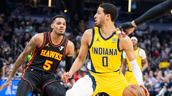Apr 14, 2024; Indianapolis, Indiana, USA; Indiana Pacers guard Tyrese Haliburton (0) dribbles the ball while Atlanta Hawks guard Dejounte Murray (5) defends in the first half at Gainbridge Fieldhouse. Mandatory Credit: Trevor Ruszkowski-Imagn Images