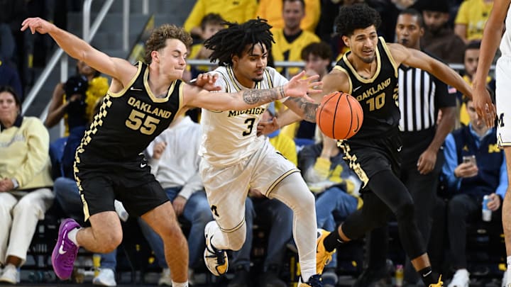 Nov 3, 2025; Ann Arbor, Michigan, USA; Michigan Wolverines guard Elliot Cadeau (3) battles for a loose ball with Oakland Golden Grizzlies guards Brody Robinson (55) and Brett White (10) in the first half at Crisler Center. Mandatory Credit: Lon Horwedel-Imagn Images Nov 3, 2025; Ann Arbor, Michigan, USA; Michigan Wolverines guard Elliot Cadeau (3) battles for a loose ball with Oakland Golden Grizzlies guards Brody Robinson (55) and Brett White (10) in the first half at Crisler Center. Mandatory Credit: Lon Horwedel-Imagn Images