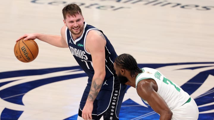 Jun 12, 2024; Dallas, Texas, USA; Dallas Mavericks guard Luka Doncic (77) reacts while dribbles the ball against Boston Celtics guard Jaylen Brown (7) during the third quarter during game three of the 2024 NBA Finals at American Airlines Center. Mandatory Credit: Kevin Jairaj-USA TODAY Sports