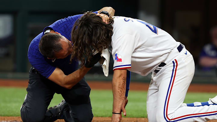 Josh Smith siendo auxiliado tras el pelotazo que recibió en el partido de los Rangers de Texas contra los Orioles de Baltimore