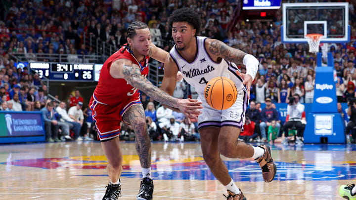 Mar 7, 2026; Lawrence, Kansas, USA; Kansas State Wildcats guard P.J. Haggerty (4) dribbles by Kansas Jayhawks guard Tre White (3) during the first half at Allen Fieldhouse. Mandatory Credit: Scott Sewell-Imagn Images