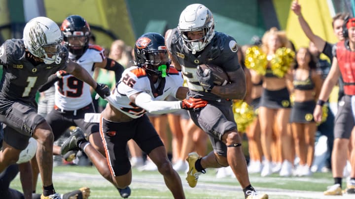 Oregon Ducks running back Makhi Hughes attempts to break a tackle by Oregon State Beavers defensive back Harlem Howard as the Oregon Ducks host the Oregon State Beavers Sept. 20, 2025, at Autzen Stadium in Eugene, Oregon.