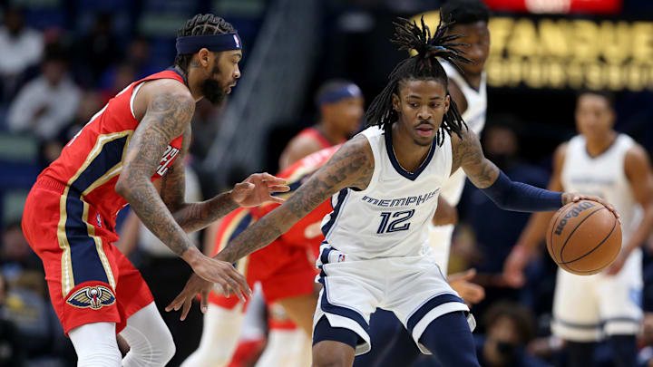 Nov 13, 2021; New Orleans, Louisiana, USA; Memphis Grizzlies guard Ja Morant (12) is defended by New Orleans Pelicans forward Brandon Ingram (14) in the first quarter at the Smoothie King Center. Mandatory Credit: Chuck Cook-Imagn Images
