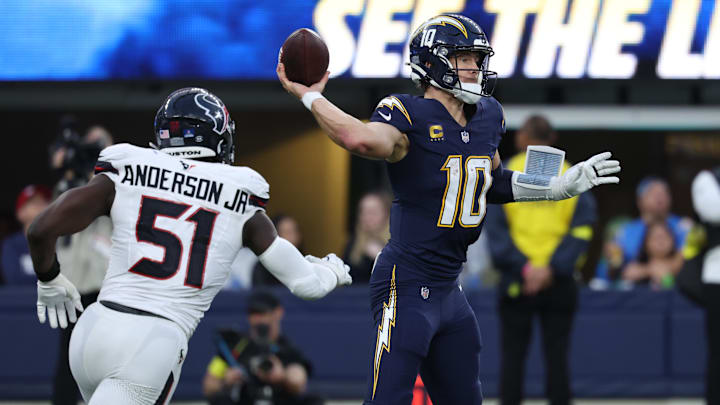 Dec 27, 2025; Inglewood, California, USA;  Los Angeles Chargers quarterback Justin Herbert (10) passes the ball as. Houston Texans defensive end Will Anderson Jr. (51) applies the pressure during the second half at SoFi Stadium. Mandatory Credit: Kiyoshi Mio-Imagn Images