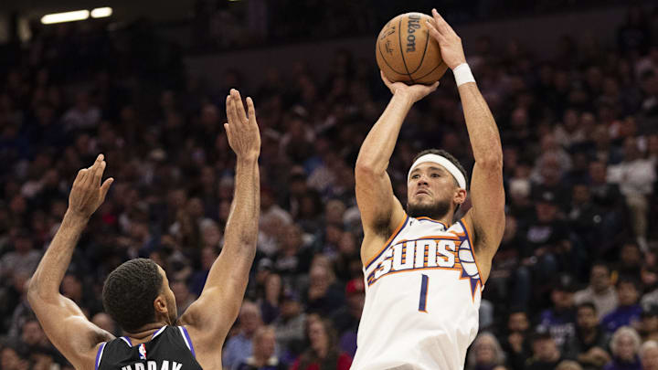 November 13, 2024; Sacramento, California, USA; Phoenix Suns guard Devin Booker (1) shoots the basketball against Sacramento Kings forward Keegan Murray (13) during the third quarter at Golden 1 Center. Mandatory Credit: Kyle Terada-Imagn Images