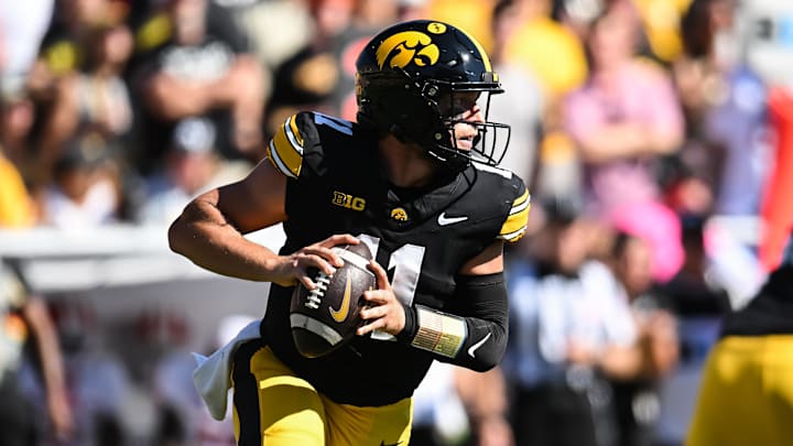 Sep 27, 2025; Iowa City, Iowa, USA; Iowa Hawkeyes quarterback Mark Gronowski (11) rolls out to throw a pass against the Indiana Hoosiers during the first quarter at Kinnick Stadium. Mandatory Credit: Jeffrey Becker-Imagn Images