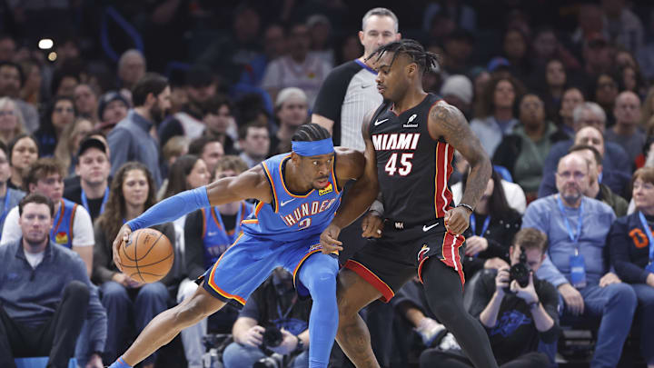 Feb 12, 2025; Oklahoma City, Oklahoma, USA; Miami Heat guard Davion Mitchell (45) defends a drive by Oklahoma City Thunder guard Shai Gilgeous-Alexander (2) during the first quarter at Paycom Center. Mandatory Credit: Alonzo Adams-Imagn Images