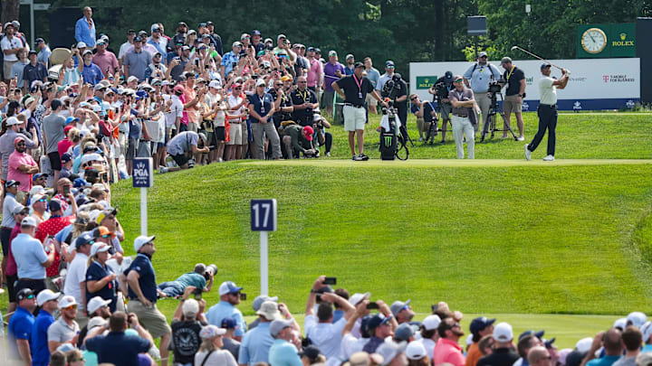 Tiger Woods drives off on the 17th tee as a large crowd of spectators watch during the 2024 PGA