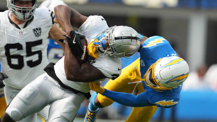 Sep 8, 2024; Inglewood, California, USA; Las Vegas Raiders running back Zamir White (left) is tackled by Los Angeles Chargers safety Derwin James Jr (3) in the second half at SoFi Stadium. Mandatory Credit: Kirby Lee-Imagn Images