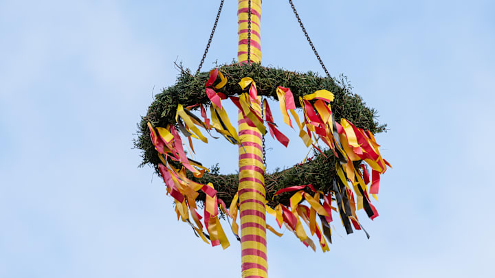 Striped maypole covered in ribbons