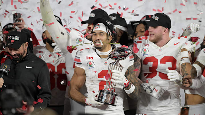Ohio State Buckeyes wide receiver Emeka Egbuka celebrates with the Leishman Trophy after defeating the Oregon Ducks.