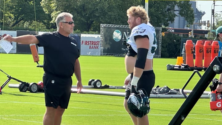 Offensive line coach Jeff Stoutland (left) gives center Cam Jurgens direction during a drill at Eagles training camp.