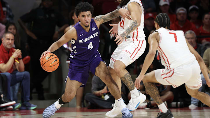 Feb 14, 2026; Houston, Texas, USA; Kansas State Wildcats guard PJ Haggerty (4) dribbles against Houston Cougars guard Emanuel Sharp (21) and  guard Milos Uzan (7)]  in the first half at Fertitta Center. 