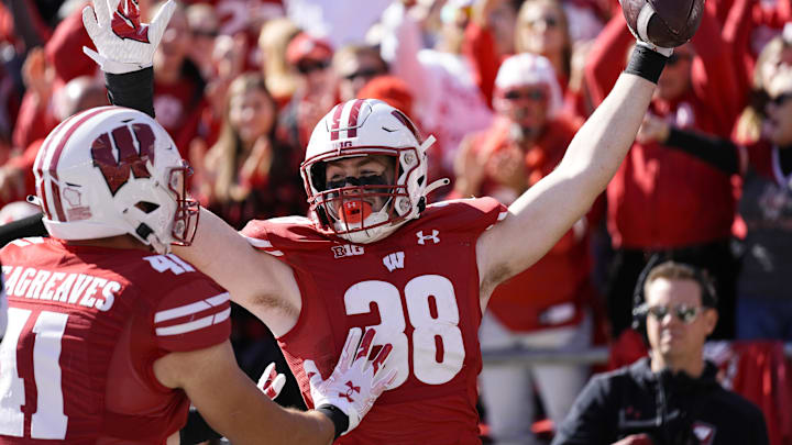 Oct 7, 2023; Madison, Wisconsin, USA; Wisconsin Badgers tight end Tucker Ashcraft (38) celebrates with wide receiver Skyler Bell (11) after scoring a touchdown during the fourth quarter against the Rutgers Scarlet Knights at Camp Randall Stadium. Mandatory Credit: Jeff Hanisch-Imagn Images Oct 7, 2023; Madison, Wisconsin, USA; Wisconsin Badgers tight end Tucker Ashcraft (38) celebrates with wide receiver Skyler Bell (11) after scoring a touchdown during the fourth quarter against the Rutgers Scarlet Knights at Camp Randall Stadium. Mandatory Credit: Jeff Hanisch-Imagn Images