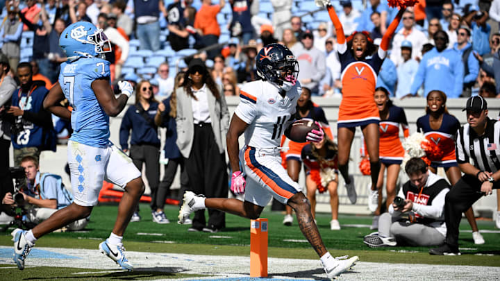 Oct 25, 2025; Chapel Hill, North Carolina, USA; Virginia Cavaliers wide receiver Trell Harris (11) breaks a tackle and scores a touchdown as North Carolina Tar Heels linebacker Khmori House (7) defends in the second quarer at Kenan Stadium. Mandatory Credit: Bob Donnan-Imagn Images Oct 25, 2025; Chapel Hill, North Carolina, USA; Virginia Cavaliers wide receiver Trell Harris (11) breaks a tackle and scores a touchdown as North Carolina Tar Heels linebacker Khmori House (7) defends in the second quarer at Kenan Stadium. Mandatory Credit: Bob Donnan-Imagn Images