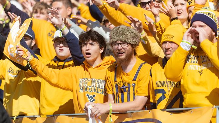 Oct 17, 2026; Morgantown, West Virginia, USA; West Virginia Mountaineers fans cheer during the first quarter against the Cincinnati Bearcats at Milan Puskar Stadium. Mandatory Credit: Ben Queen-Imagn Images Oct 17, 2026; Morgantown, West Virginia, USA; West Virginia Mountaineers fans cheer during the first quarter against the Cincinnati Bearcats at Milan Puskar Stadium. Mandatory Credit: Ben Queen-Imagn Images