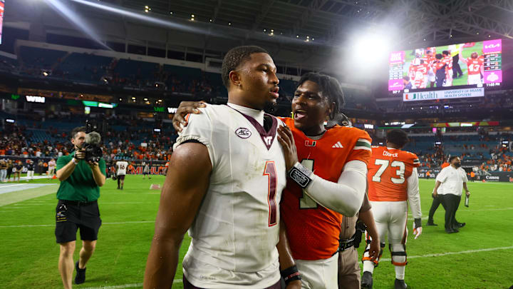 Sep 27, 2024; Miami Gardens, Florida, USA; Miami Hurricanes quarterback Cam Ward (1) and Virginia Tech Hokies quarterback Kyron Drones (1) talk on the field after the game at Hard Rock Stadium. Mandatory Credit: Sam Navarro-Imagn Images