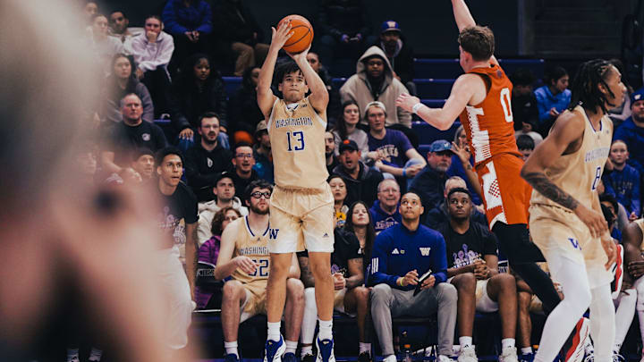 Jase Butler lets fly with a 3-pointer in front of the UW bench. 