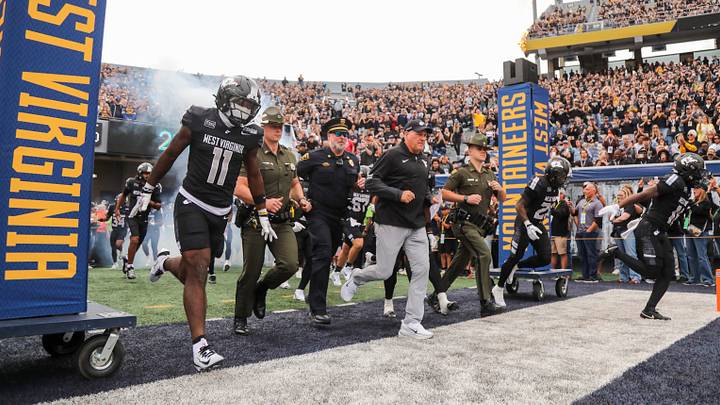 Oct 10, 2026; Morgantown, West Virginia, USA; West Virginia Mountaineers head coach Rich Rodriguez leads his team onto the field befroe their game against the Arizona Wildcats at Milan Puskar Stadium. Mandatory Credit: Ben Queen-Imagn Images Oct 10, 2026; Morgantown, West Virginia, USA; West Virginia Mountaineers head coach Rich Rodriguez leads his team onto the field befroe their game against the Arizona Wildcats at Milan Puskar Stadium. Mandatory Credit: Ben Queen-Imagn Images