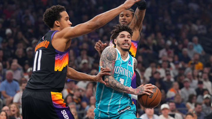 Charlotte Hornets guard LaMelo Ball (1) drives against Phoenix Suns forward Oso Ighodaro (11) nd Phoenix Suns guard Jalen Green