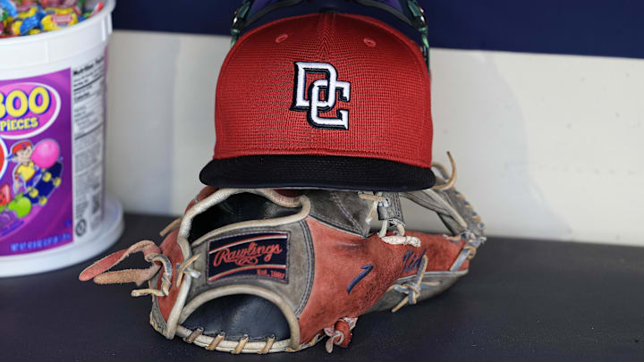 Jul 12, 2024; Milwaukee, Wisconsin, USA;  An Washington Nationals hat and glove sit in the dugout during batting practice prior to the game against the Milwaukee Brewers at American Family Field. 