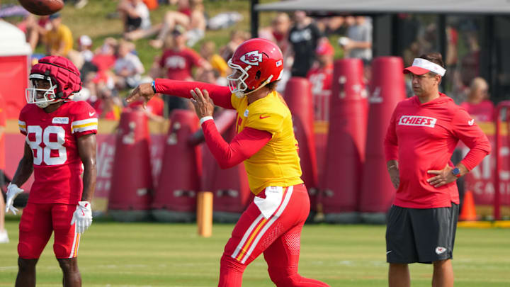 Jul 26, 2024; Kansas City, MO, USA; Kansas City Chiefs quarterback Patrick Mahomes (15) throws a pass as general manager Brett Veach watches in the background during training camp at Missouri Western State University. Mandatory Credit: Denny Medley-USA TODAY Sports
