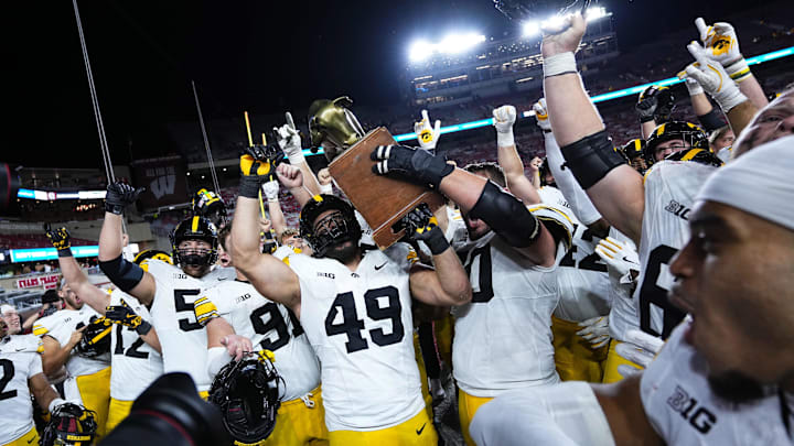 Oct 11, 2025; Madison, Wisconsin, USA; The Iowa Hawkeyes celebrate a win with The Heartland Trophy after the game against the Wisconsin Badgers at Camp Randall Stadium. Mandatory Credit: Ross Harried-Imagn Images Oct 11, 2025; Madison, Wisconsin, USA; The Iowa Hawkeyes celebrate a win with The Heartland Trophy after the game against the Wisconsin Badgers at Camp Randall Stadium. Mandatory Credit: Ross Harried-Imagn Images