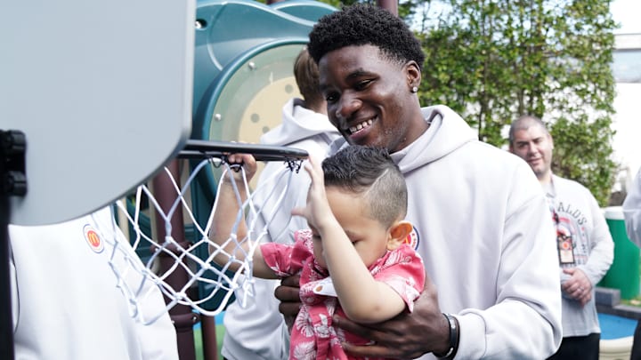 Tounde Yessoufou of Santa Maria St. Joseph (CA) helps a young boy dunk on a toy hoop during a visit to the Ronald McDonald House in New York on Saturday, March 29, 2025.