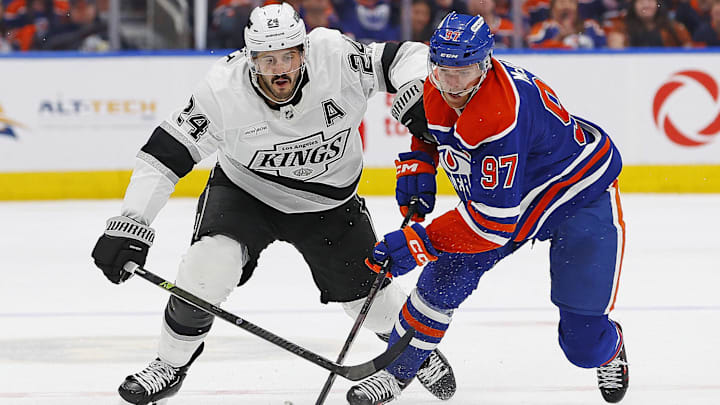 May 1, 2025; Edmonton, Alberta, CAN; Los Angeles Kings forward Phillip Danault (24) tries to knock the puck away from Edmonton Oilers forward Connor McDavid (97) during the second period in game six of the first round of the 2025 Stanley Cup Playoffs at Rogers Place. Mandatory Credit: Perry Nelson-Imagn Images