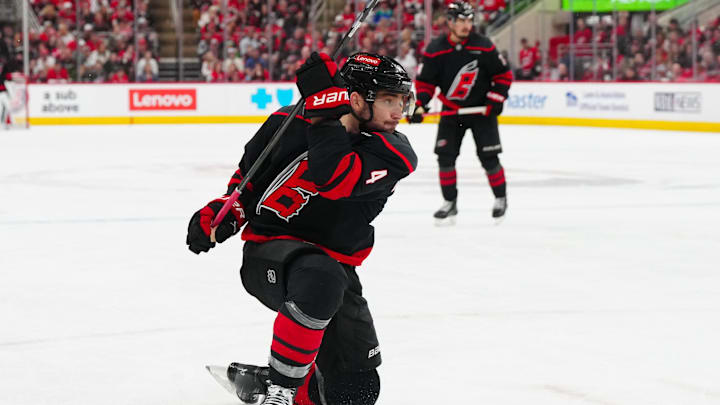 Apr 22, 2025; Raleigh, North Carolina, USA; Carolina Hurricanes defenseman Shayne Gostisbehere (4) takes a shot against the New Jersey Devils during the third period in game two of the first round of the 2025 Stanley Cup Playoffs at Lenovo Center.
